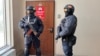 Сотрудники полицейского спецназа у двери редакции Orda.kz в Алматы. 1 декабря 2025 года