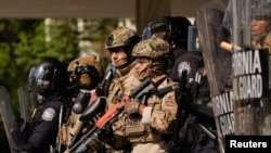 Солдаты Нацгвардии и полицейские стоят на страже во время митинга против рейдов Иммиграционной и таможенной полиции США (ICE) в Лос-Анджелесе, 9 июня 2025 года. Фото Рейтер