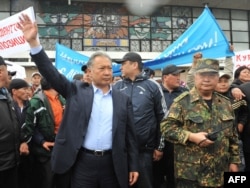 Бийликтен кулатылган Курманбек Бакиев (солдо) иниси Жаныш Бакиев (оңдо) менен апрель окуясынан кийинки митингде. Ош шаары, 15-апрель, 2010