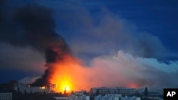 Foc și fum se ridică de la locul unde o rachetă rusească a lovit o zonă rezidențială din Harkov, Ucraina, pe 7 iunie.