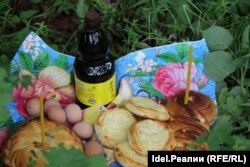 A bottle of kvass, along with eggs, bread, and pies stuffed with ruble coins