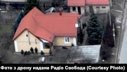 Російські військові під час так званої зачистки в Бучі. Біля них тіло вбитого цивільного чоловіка