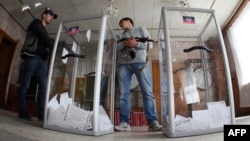 Armed pro-Russian activists stand guard near ballot boxes during the referendum called by pro-Russian rebels to split from the rest of Ukraine on May 11 in Donetsk. 