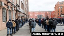 Беткапчан мигранттар каттоосун узартуу үчүн Санкт-Петербургдагы миграциялык кызматта кезек күтүп турушат. 3-апрель, 2020-жыл.