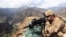 FILE: A U.S. soldier looks trough his sniper scope at a observation post in the eastern Afghan province of Kunar near the border with Pakistan.