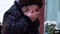 A woman cries as she lays flowers at an impromptu memorial outside a Moscow theater that housed the Aleksandrov Ensemble. Dozens of members of the renowned choir died when the military plane they were traveling on crashed into the Black Sea on December 25.