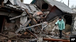 O femeie lângă ce a mai rămas din casa ei, după bombardamentele rusești de miercuri, Kurahove, regiunea Donețk, Ucraina, joi, 8 dec. 2022