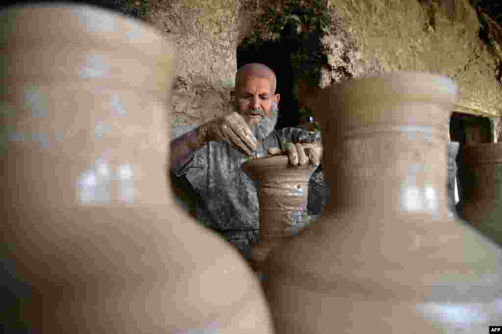 Өзүнүн өнөрканасында чоподон идиштерди жасап жаткан уста. Кандагар, Ооганстан. 