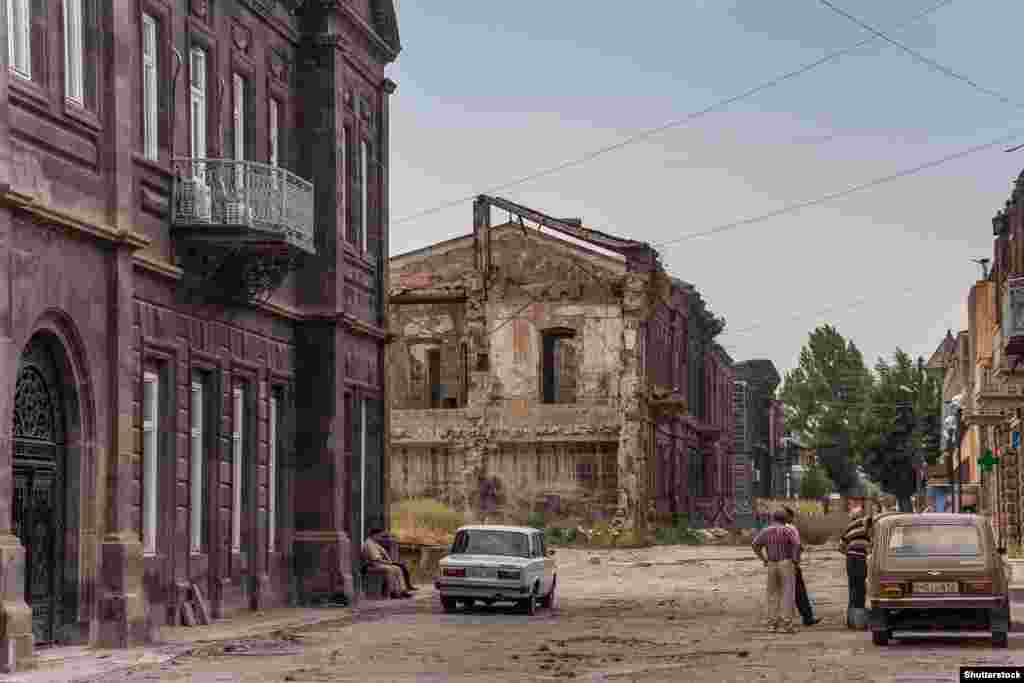 Earthquake-damaged buildings in Gyumri in 2013. Since the quake, which destroyed most of the town's factories, the population has nearly halved. For quake survivors and many other Armenians, the lure of a job in neighboring Russia is strong. One Gyumri local told a reporter in 2013 that "unemployment and poverty are more terrifying" than the prospect of another earthquake.