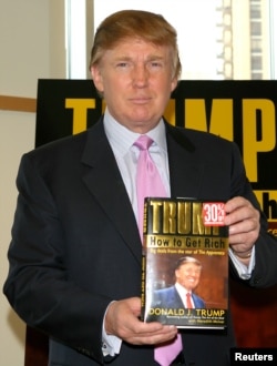 Дональд Трамп тримає примірник своєї книги «Як розбагатіти» під час церемонії підписання в книгарні Barnes & Noble в Нью-Йорку, 24 березня 2004 року