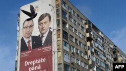 Un banner cu liderii Uniunii Social-Liberale (USL), premierul român Victor Ponta (L) și liderul Partidului Național Liberal Crin Antonescu (R) este postat pe un bloc din București, România, pe 8 decembrie 2012. Alegeri parlamentare, 9 decembrie 2012.