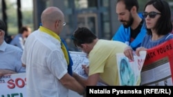 Перехожі підписують листівку до дня народження Сенцова