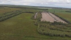 Функционирующий куст на Приобском месторождении. Шламовые амбары слева