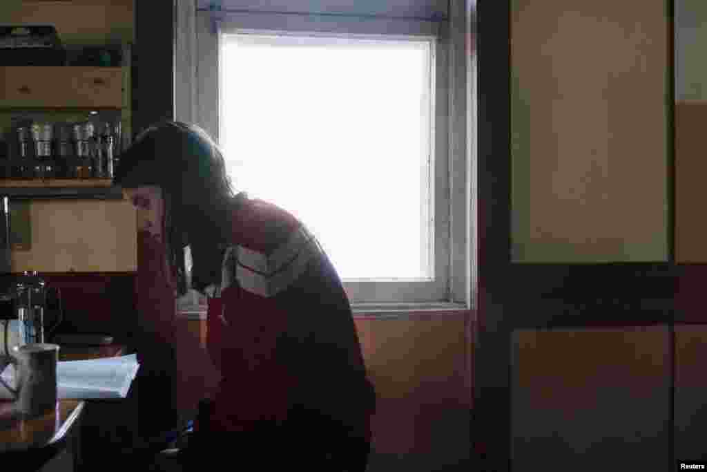 Activist Yekaterina Samutsevich reads a book as she waits for the birth of fellow Voina member Natalia Sokol's first child, Kasper, in a secret hideout in Moscow in June 2009.