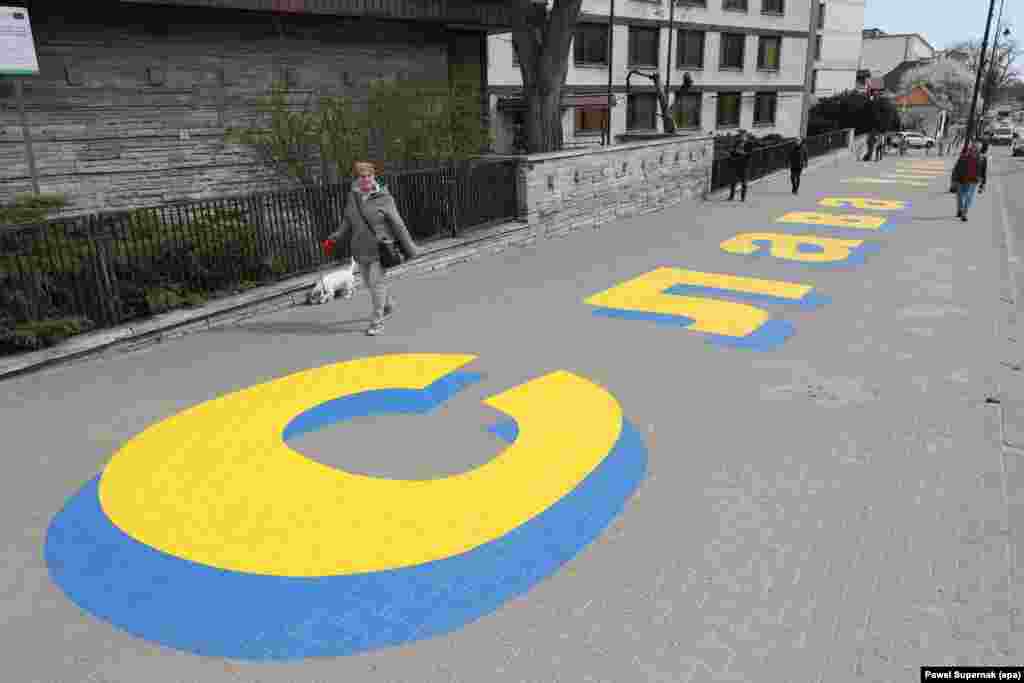 پیامی به زبان اوکراینی که در پیاده‌روی بیرون سفارت روسیه در ورشو، لهستان، با مضمون «درود بر اوکراین» نوشته شده؛ عکسی که در آوریل ۲۰۲۲ گرفته شده است.