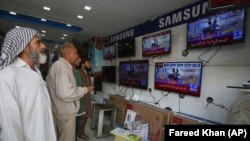 FILE: Pakistani viewers watch news bulletins on television in Karachi.