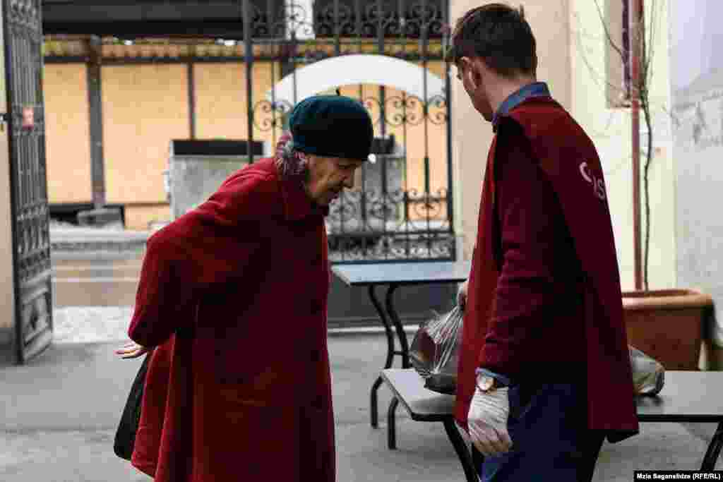 "კათარზისის" თანამშრომელი კუთვნილ ულუფას აწვდის ბენეფიციარს.