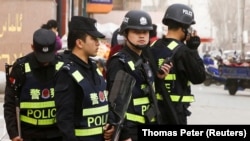 Вооруженные сотрудники китайских служб безопасности в Кашгаре, городе в Синьцзяне.