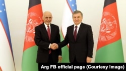 Uzbekistan's President Shavkat Mirziyoev (R) shaking hands with the Afghan President Ashraf Ghani in Tashkent on March 27.