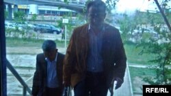 Бывший главврач роддома Жанибек Кушалиев и его адвокат идут в зал суда. Атырау, 14 мая 2009 года.