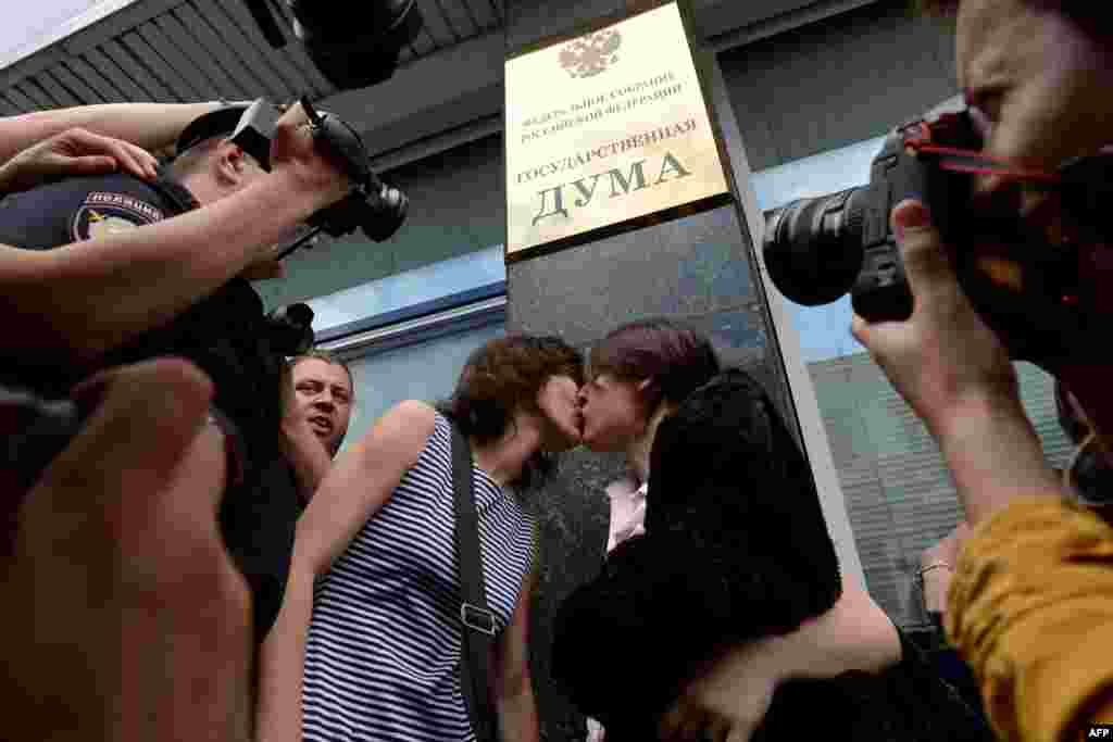 Gay-rights activists kiss each other outside the State Duma.