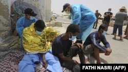 Мигранты, спасенные Национальной гвардией Туниса во время попытки пересечь Средиземное море на лодке. Порт Эль-Кетеф недалеко от границы с Ливией. 27 июня 2021 года