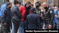 Polisiýa Bulgarystanyň paýtagty Sofiada toplanan adamlar bilen gürleşýär. Aprel, 2020 ý. 