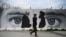 FILE: A man walks past a wall painted with images of U.S. Special Representative for Afghanistan Reconciliation Zalmay Khalilzad (L) and Taliban co-founder Mullah Abdul Ghani Baradar.