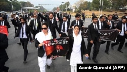 Lawyers display placards as they march along a street during an anti-France demonstration near the French Embassy in Islamabad on November 12.
