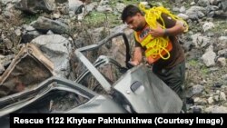 د ژغورنې ادارې يو کارکوونکی د مې پر لومړۍ نېټه په کوز کوهستان کې کندې ته لوېدلي ګاډی ګوري.