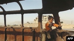 An Afghan boy plays in the remains of a Soviet bus in Kabul (file photo)