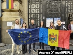 Voters hold up the EU and Moldovan flags at a polling center in Chisinau on September 28.