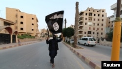 بیرق داعش در دست یکی از افراد مسلح این گروه. عکس از آرشیف