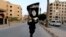 A member of Islamic State militants waves the group's flag in the Syrian city of Raqqa in June.
