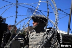 A U.S. soldier, part of a NATO peace force, places barbed wire on his Humvee during a protest in the ethnically divided town of Mitrovica. (file photo)
