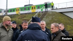 Прем'єр-міністр Польщі Дональд Туск (праворуч) оглядає місце пошкодження залізничних колій на лінії Варшава-Люблін після вибуху, який він назвав «безпрецедентним актом диверсії».