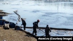Остатки нефтесодержащей жидкости убирают с поверхности реки в Коми 