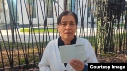 Рўзигул Бобоева Ўзбекистон паспортидаги "Фуқаролар давлат ҳимоясида" деган ёзувни кўрсатиб турибди. 