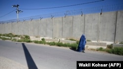 Avganistanka obučena u burku prolazi pored američke vojne baze, u blizini Kabula, 1. jul 2021.