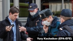 Moscow police officers stop a man for allegedly breaking self-isolation rules amid a coronavirus lockdown on April 9.