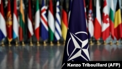 Drapelul NATO în fața celorlalte steaguri care formează alianța. Liderii celor 32 de țări membre și invitați importanți din afara alianței se reunesc săptămâna viitoare la Washington.