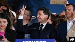 Nicușor Dan arată semnul victoriei după afișarea primelor estimări ale rezultatelor prezidențiale din primul tur, 4 mai 2025.
