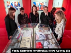 Tinere care admiră o expoziție la scurt timp după deschiderea acesteia.