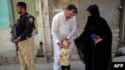 یو روغتیايي کارکوونکی یو ماشوم ته د ګوزڼ واکسیني څاڅکي ورکوي - پخوانی انځور. 