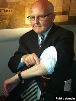 Оунівець Омелян Коваль показує свій номер в концтаборі «Аушвіц», витатуюваний на руці