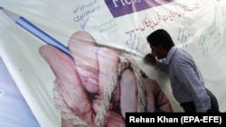 FILE: A Pakistani journalist signs a banner during a protest to mark World Press Freedom day in Karachi in May 2018.