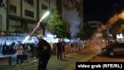 Pristalice vlasti okupljene ispred prostorija Srpske napredne stranke bacaju pirotehnička sredstva na demonstrante u Novom Sadu, 13, avgust 2025.