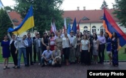 Олексій Бессарабов (четвертий ліворуч) тримає прапор України на випуску слухачів Варшавської євроатлантичної літньої академії, 26 липня 2013 року