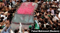 Supporters of former Pakistani Prime Minister Nawaz Sharif crowd around his car near Islamabad on August.