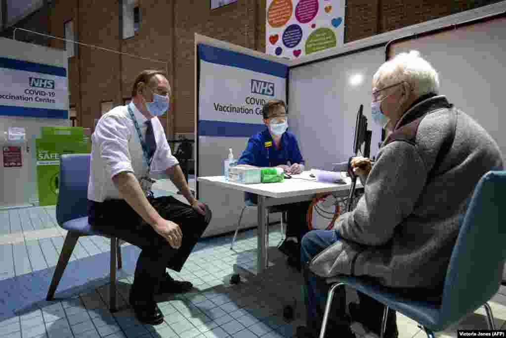 Саймон Стівенс (ліворуч), виконавчий директор NHS (Національна служба охорони здоров&rsquo;я Сполученого Королівства), розмовляє з пацієнтом, який прибув у центр вакцинації, щоб отримати дозу вакцини Pfizer/BioNTech Covid-19 у лікарні Гая. Лондон, Велика Британія, 8 грудня 2020 року 